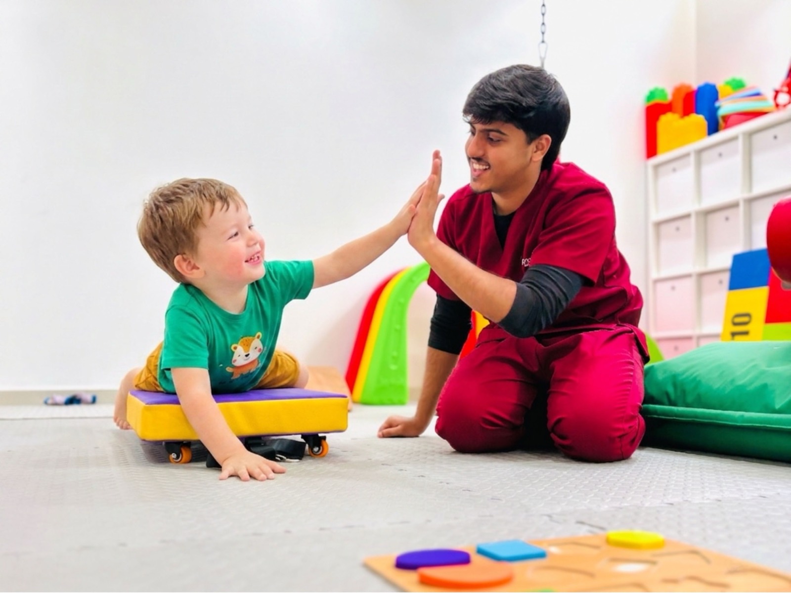 Child and therapist sharing a high-five during a therapy session at Bridges Care Speech Therapy Center