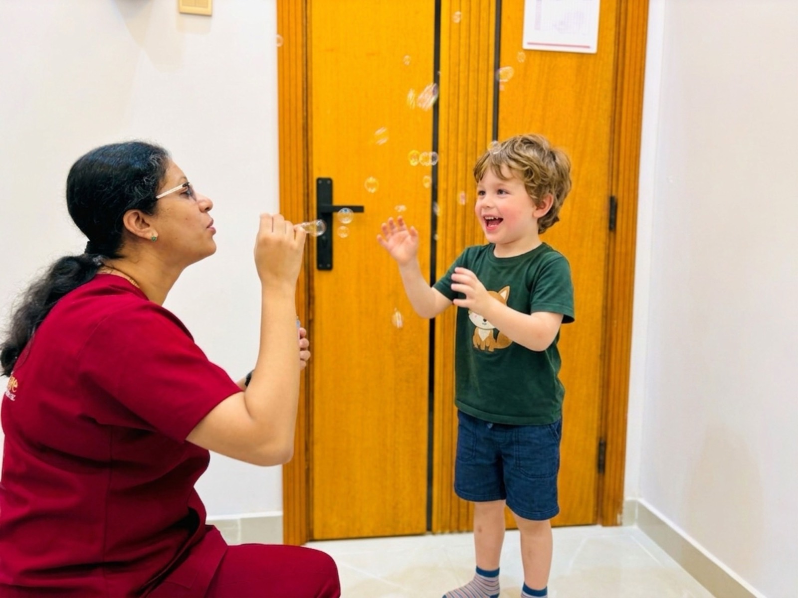 Child delighting in bubbles during a playful speech therapy session at Bridges Care